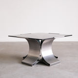 Modern metal table with a glass top on a plain background