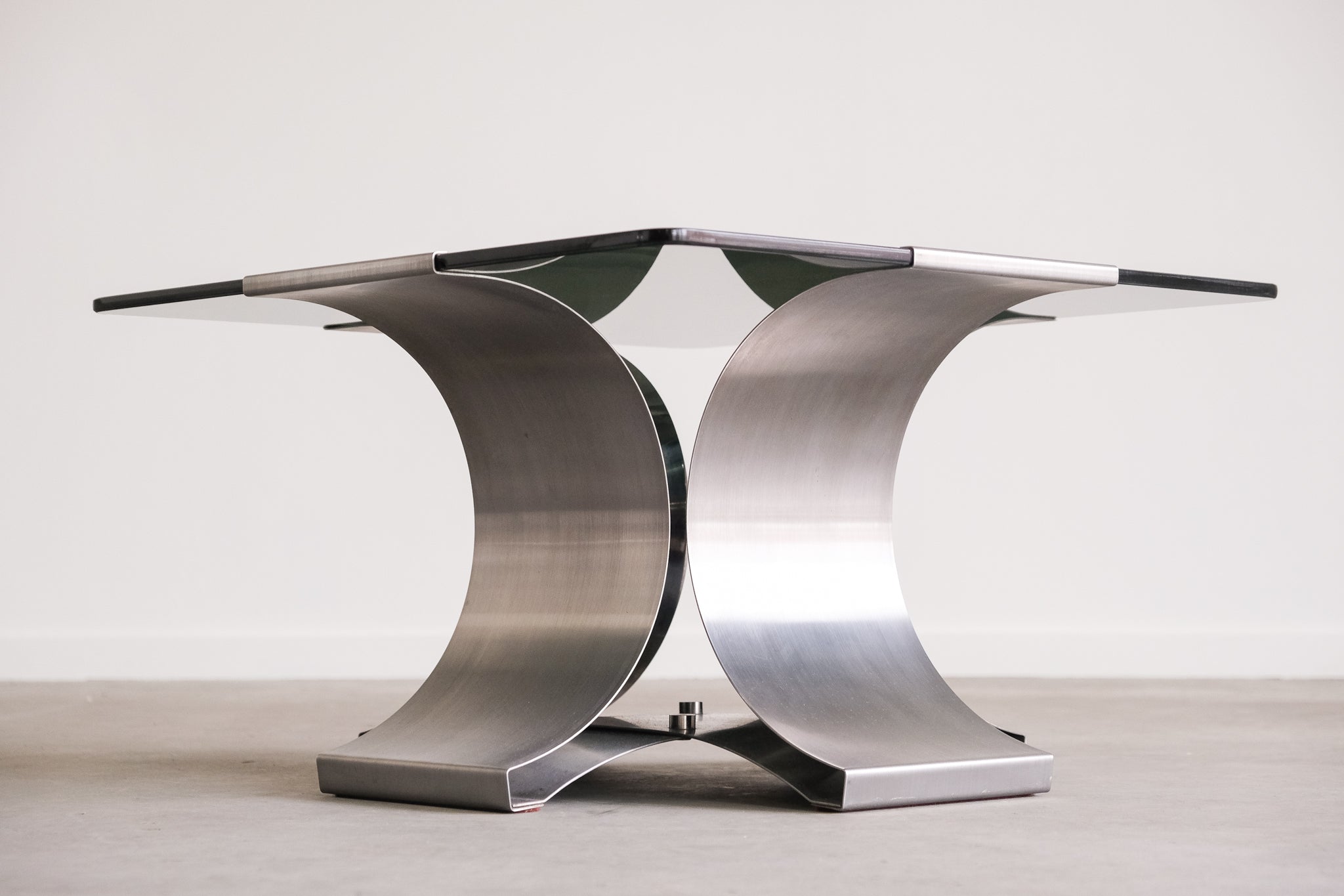 Modern metal table with a sleek design on a plain background