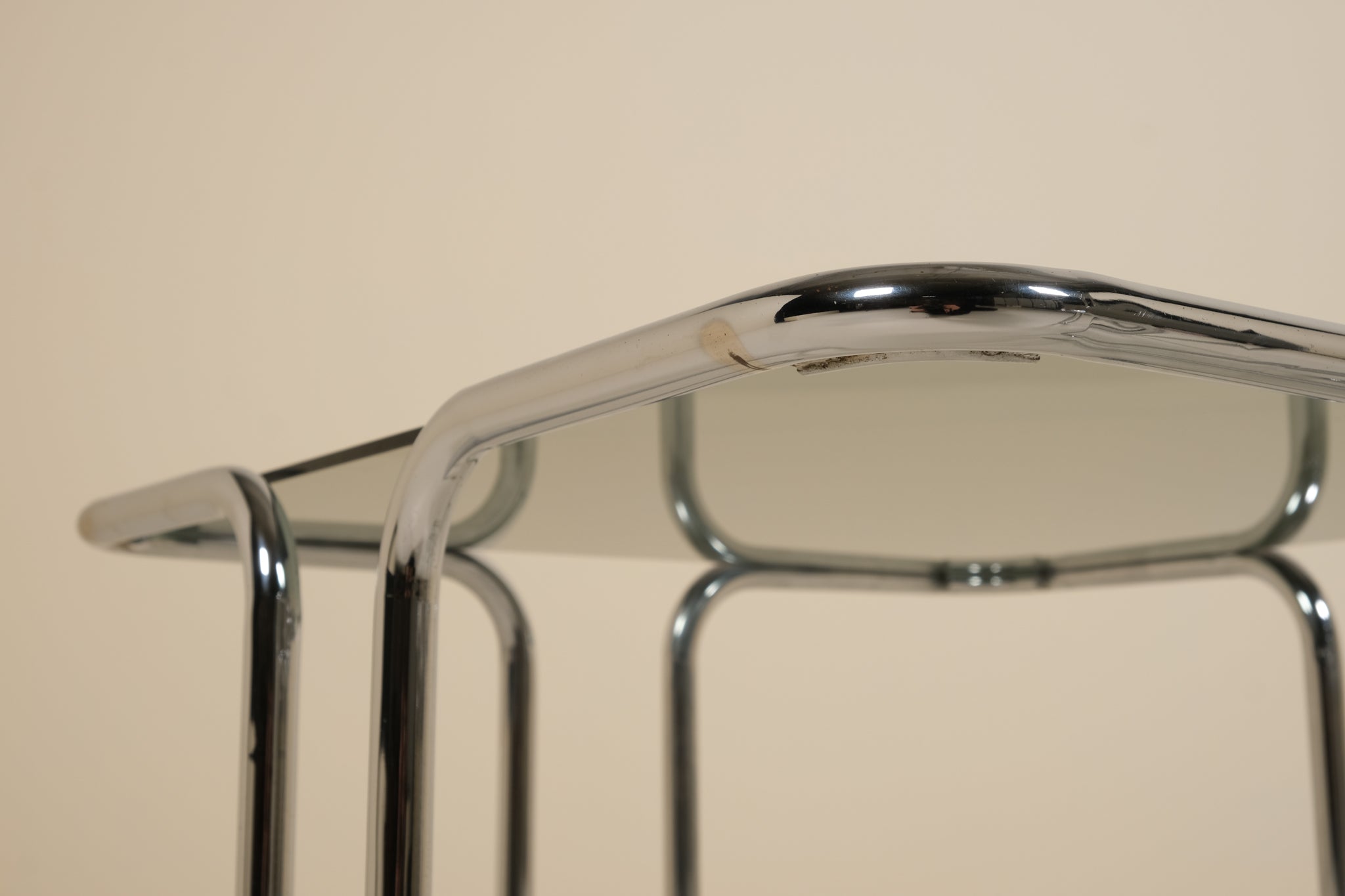 Close-up of a metallic table with a beige background