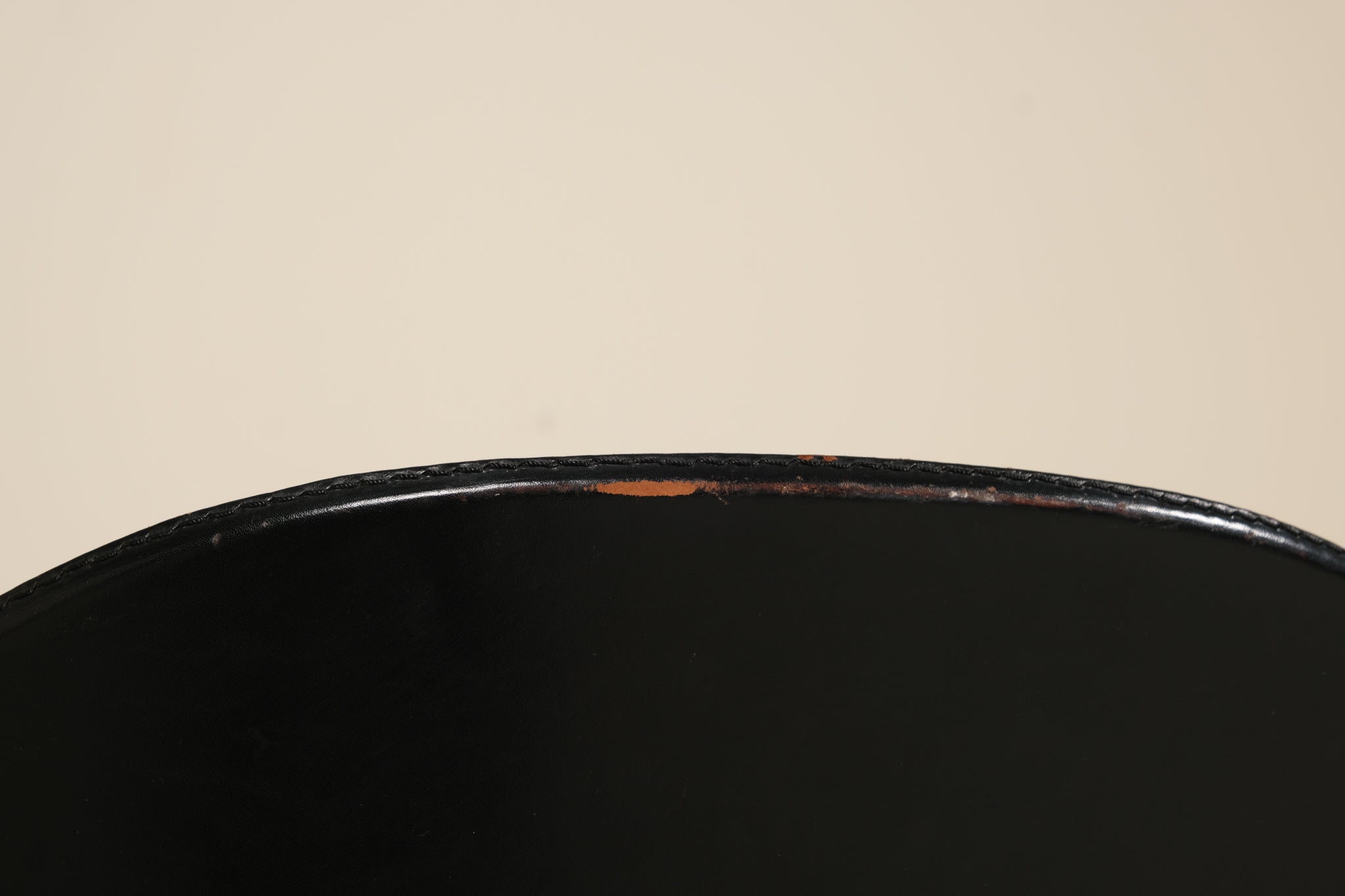 Close-up of a black surface with a beige background