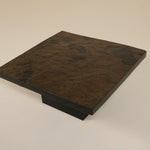 Dark brown stone slab on a beige background