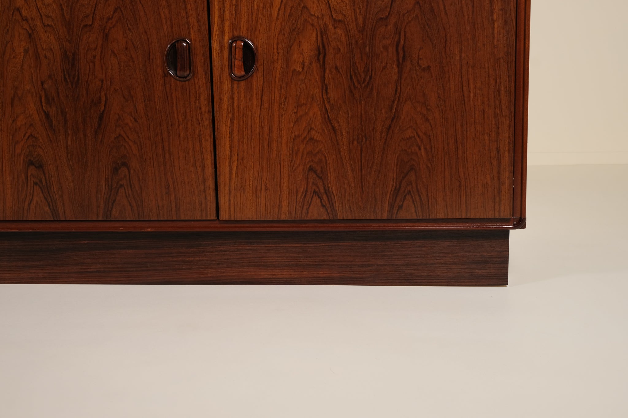 Close-up of a wooden cabinet with a smooth finish on a beige background