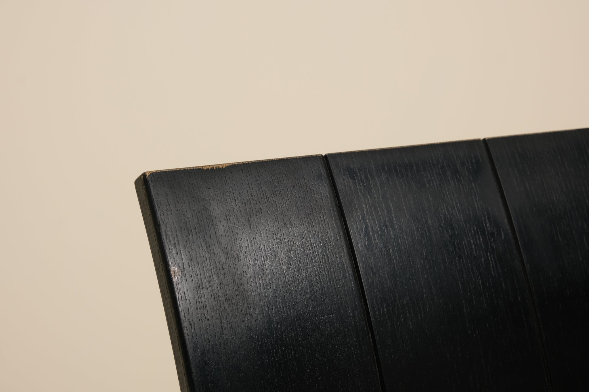 Close-up of a black metal strip chair on a beige background