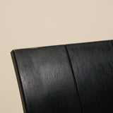 Close-up of a black metal strip chair on a beige background