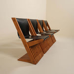 Row of wooden chairs with black leather seats on a beige background