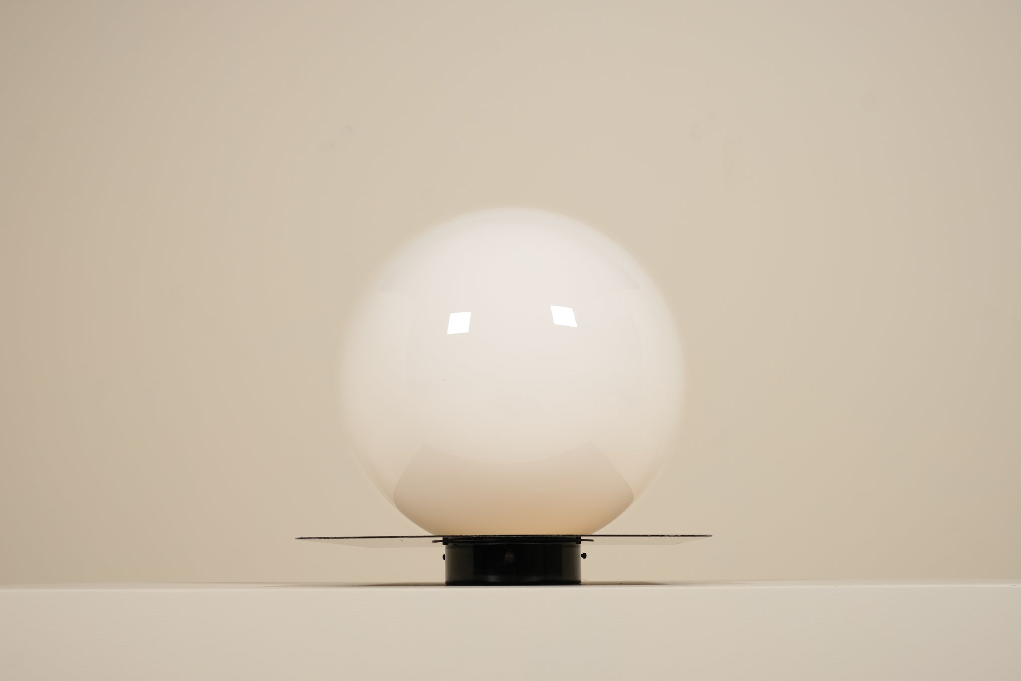 Glossy white sphere on a beige background
