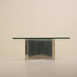 Glass dining table with metallic base on a beige background