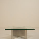 Glass table with metal base on a beige background