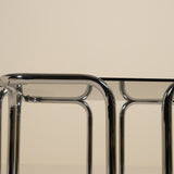 Close-up of a chrome table frame with a beige background