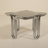 Modern glass table with chrome legs on a beige background