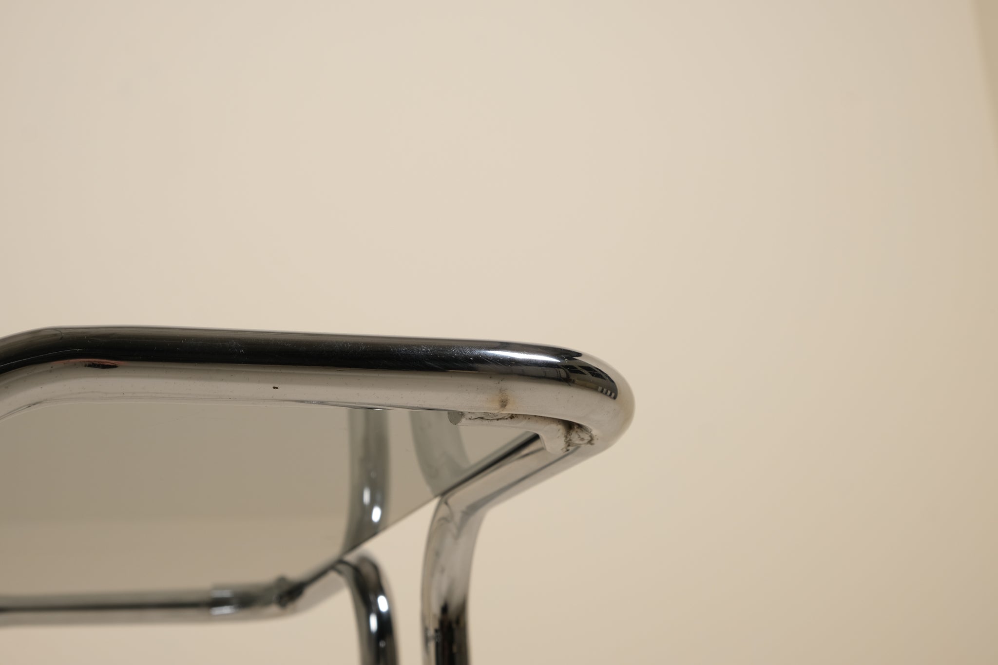 Close-up of a metallic table with a reflective surface on a beige background