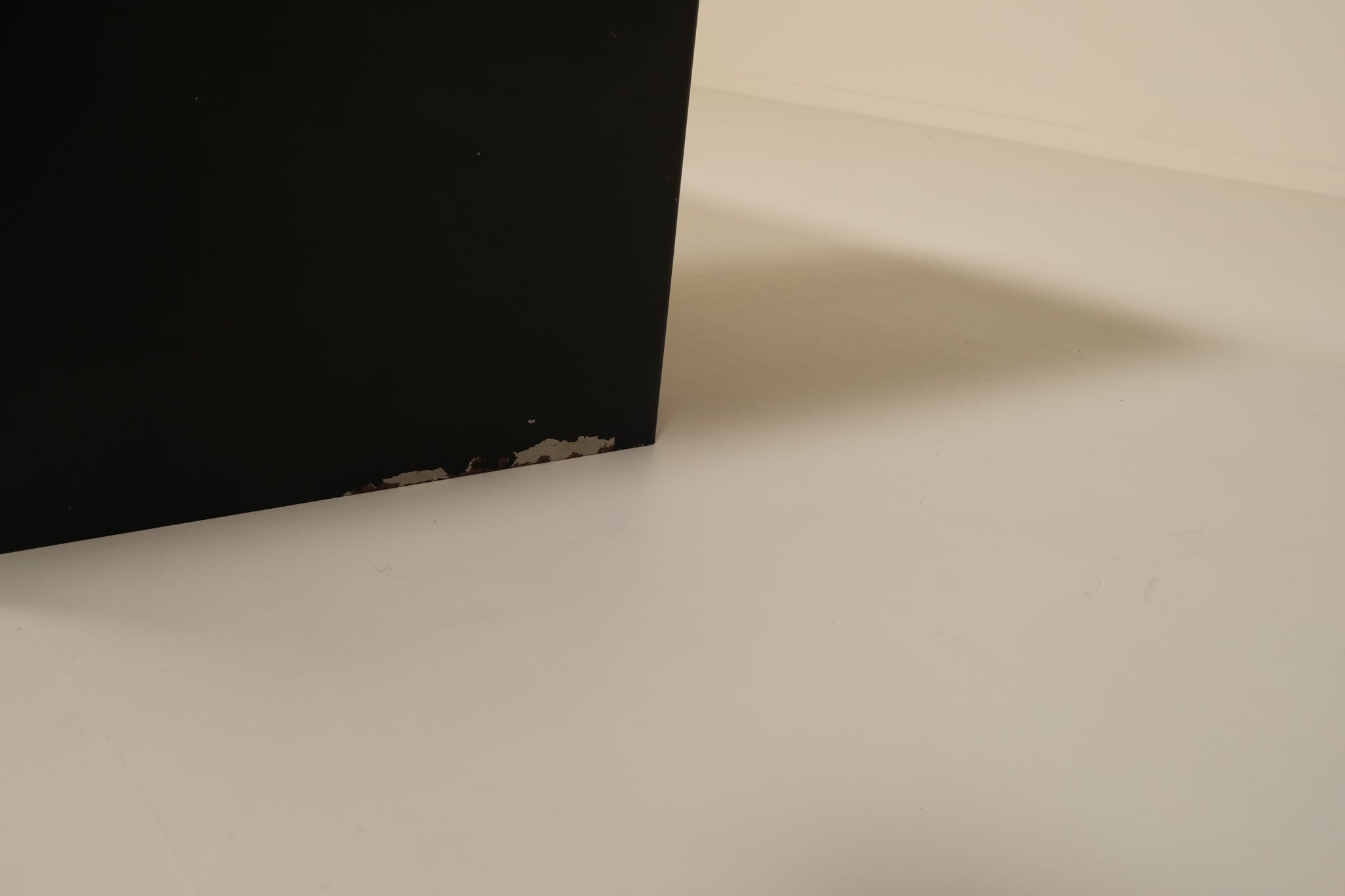 Close-up of a black base object on a beige surface