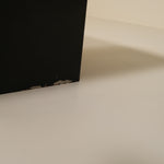 Close-up of a black base object on a beige surface