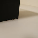 Close-up of a black base object on a beige surface