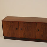 Wooden sideboard with four doors on a plain background