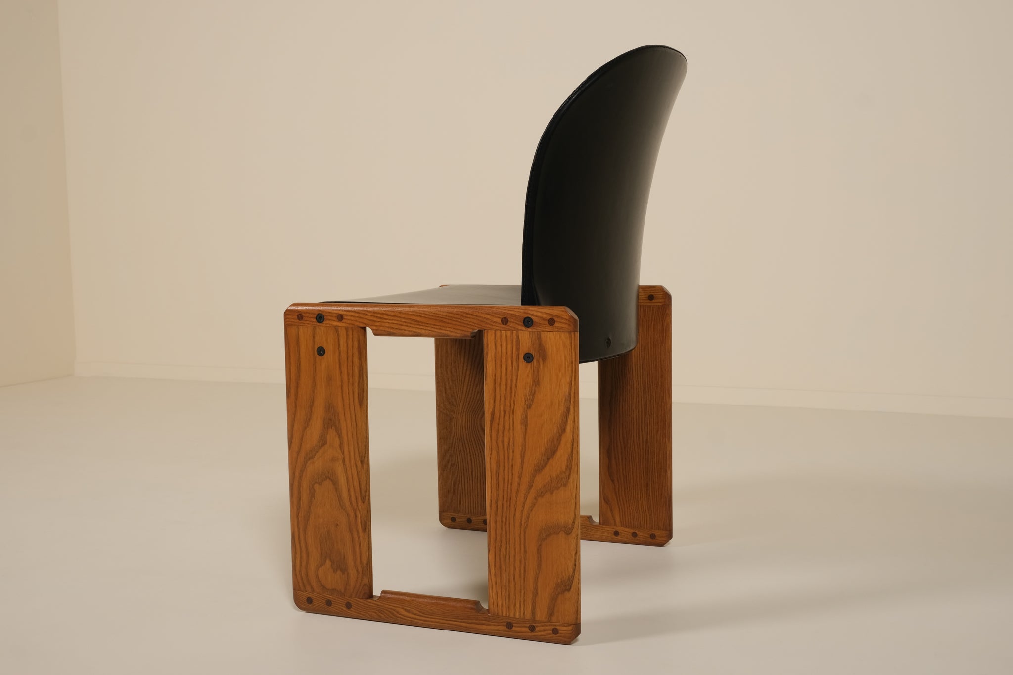 Wooden chair with a black seat and backrest on a beige background