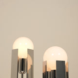 Two modern table lamps with glass shades on a neutral background
