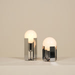 Two modern table lamps with glass shades on a neutral background