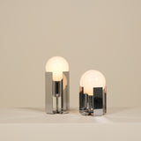 Two modern table lamps with glass shades on a neutral background