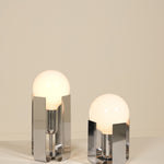 Two modern table lamps with glass shades on a neutral background
