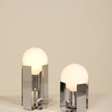 Two modern table lamps with glass shades on a neutral background