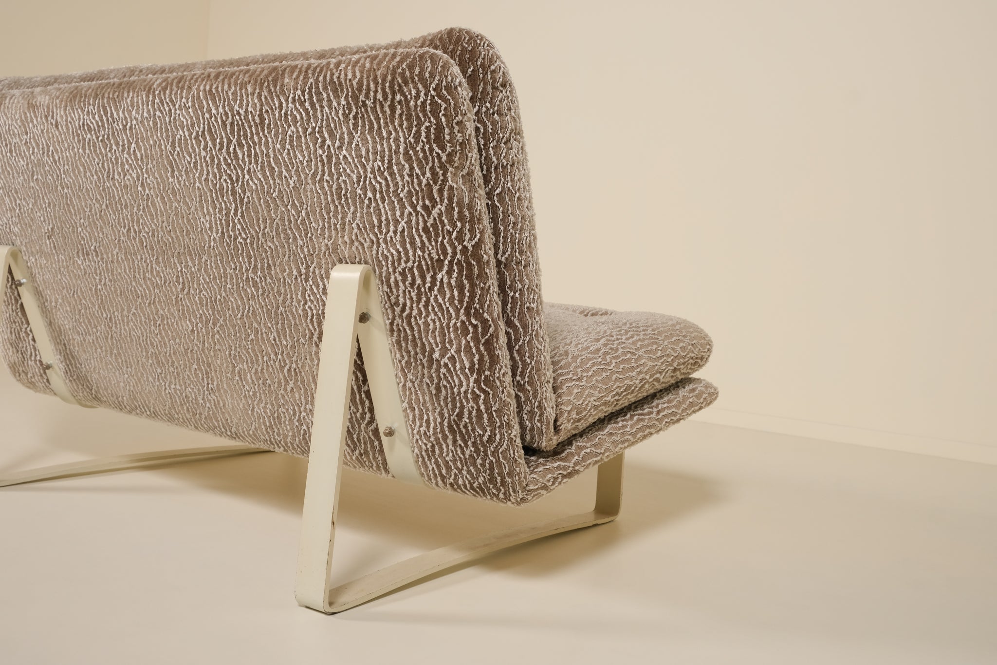 Back of a kho liang sofa with textured fabric on a beige background