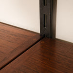 Close-up of a wooden shelf corner with a metal bracket.