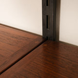 Close-up of a wooden shelf corner with a metal bracket.