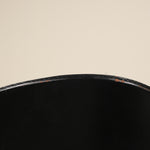 Close-up of a black chair seat on a beige background