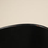 Close-up of a black chair seat on a beige background