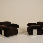 Two dark brown armchairs on a beige background
