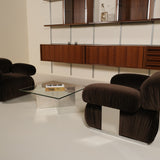Modern living room with brown armchairs and a glass coffee table.