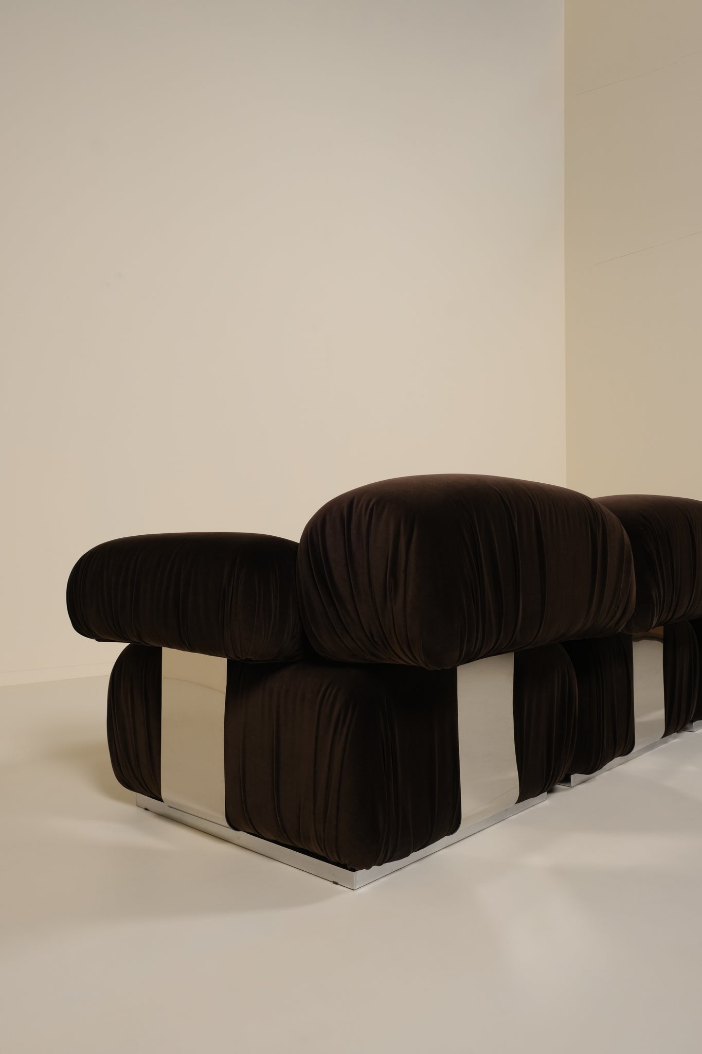 Brown sofa with a checkered pattern on a white floor and wall