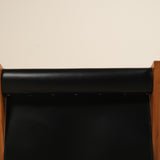 Black leather seat with wooden frame on a beige background