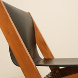 Wooden chair with black seat and backrest on a beige background