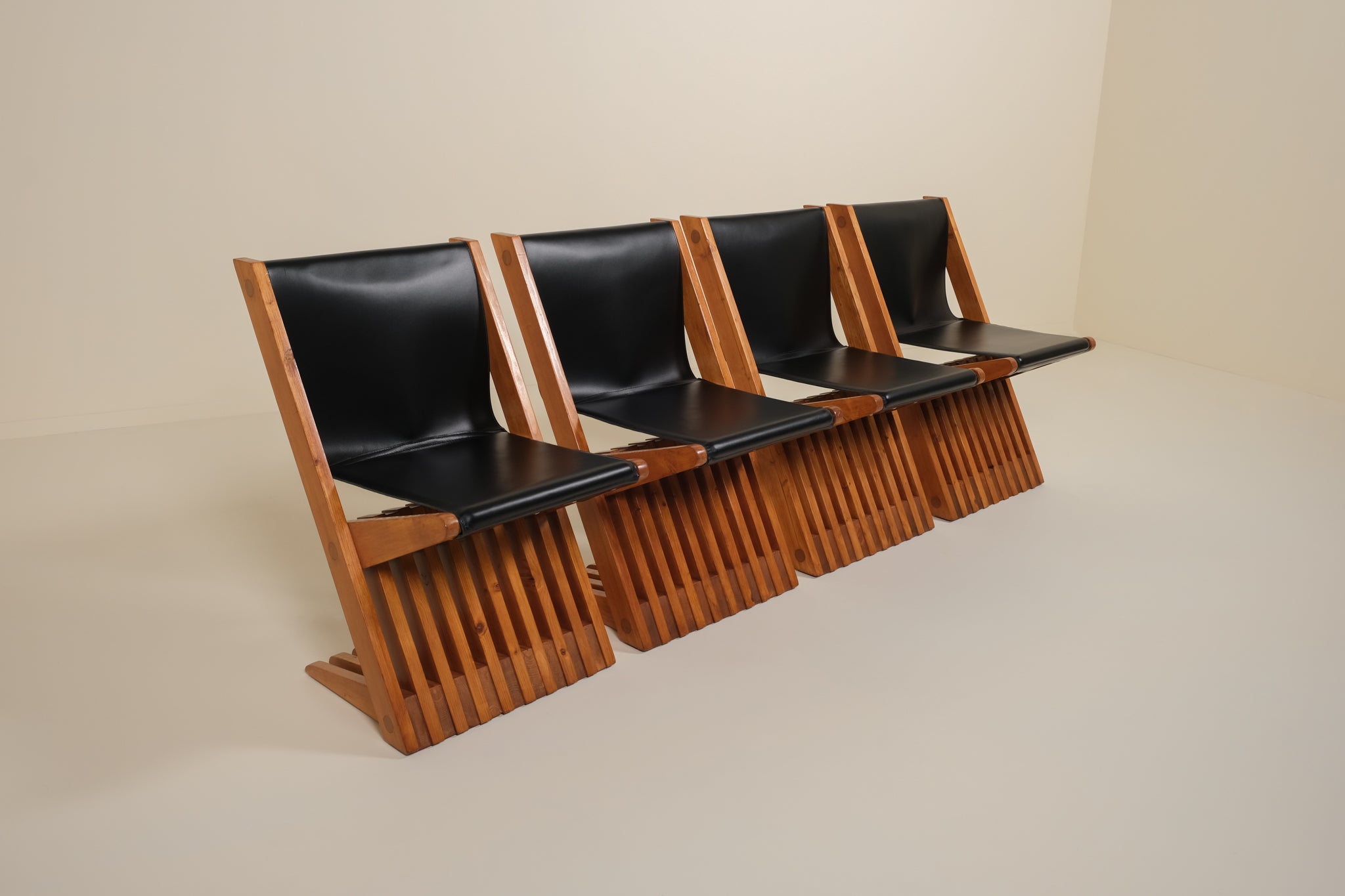 Row of black leather seats with wooden frame on a beige background