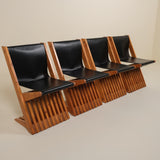 Row of black leather seats with wooden frame on a beige background