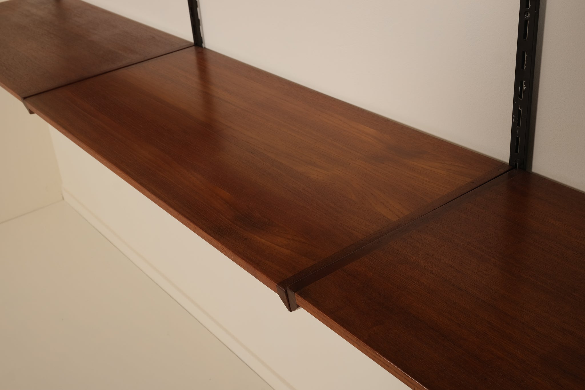 Wooden shelf with against a plain wall