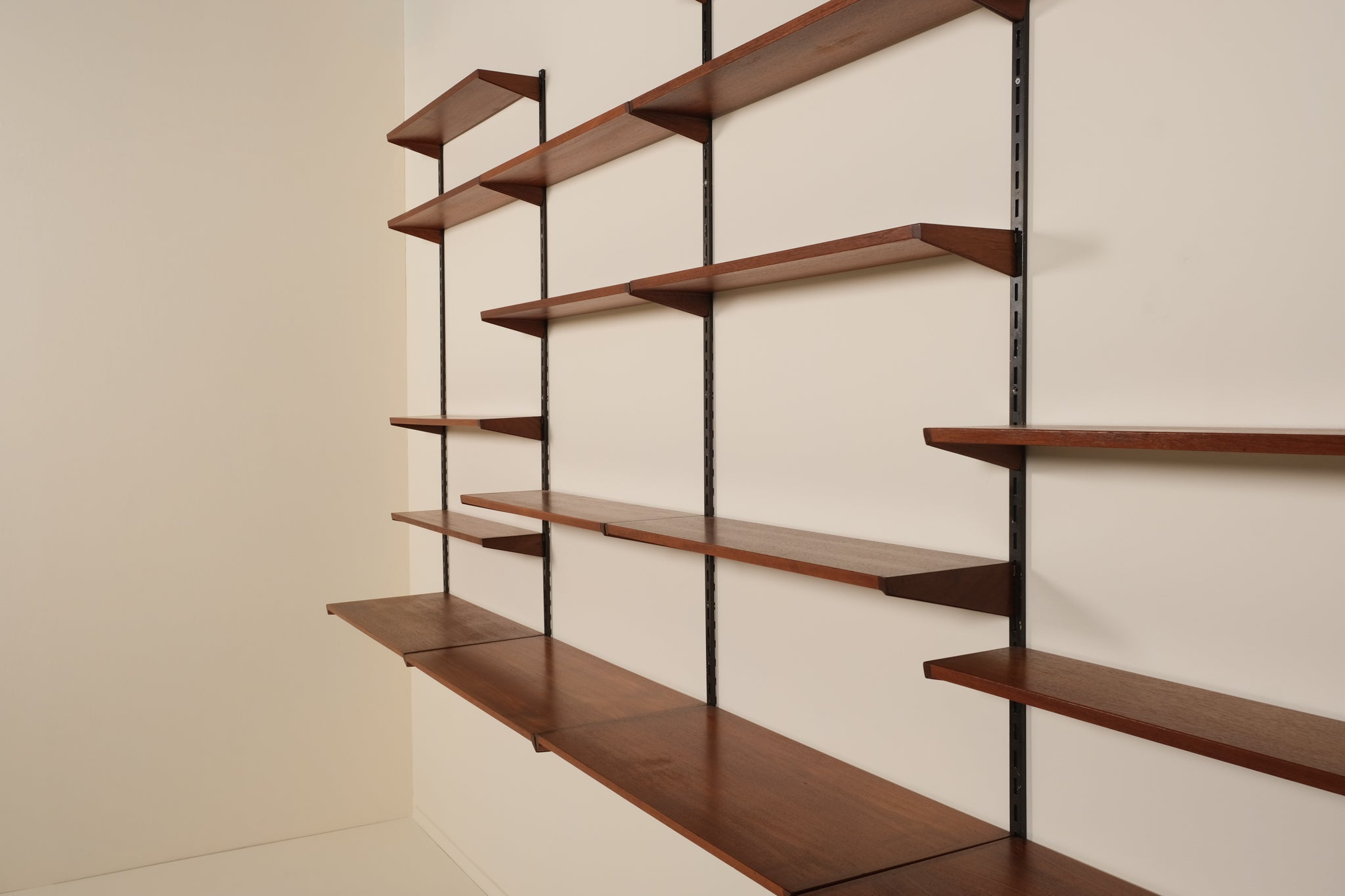 Wooden shelves with metal brackets against a beige wall