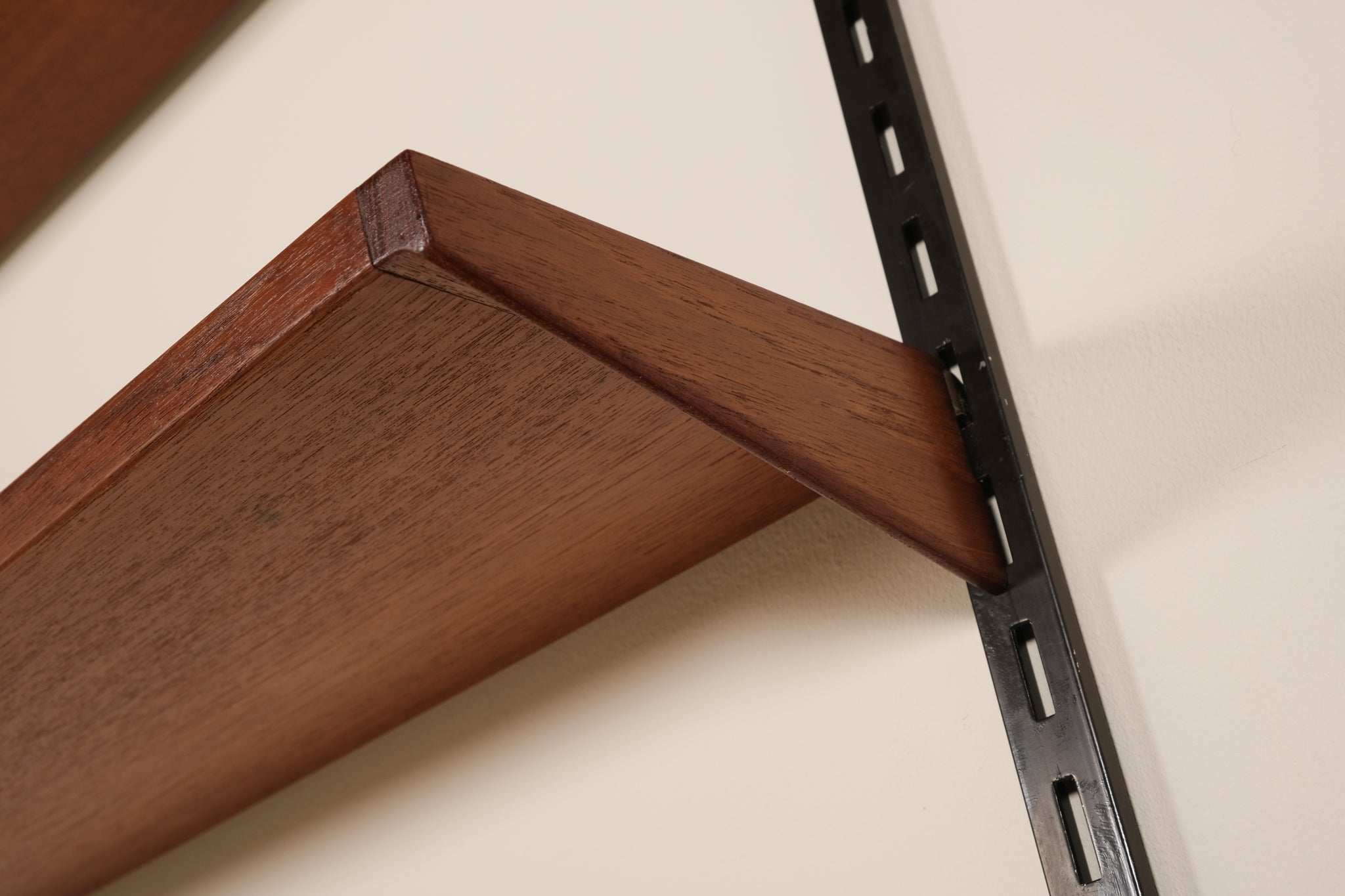 Wooden shelf bracket attached to a wall with a metal bracket.
