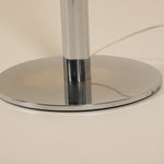 Chrome lamp base on a beige background
