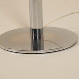 Chrome lamp base on a beige background
