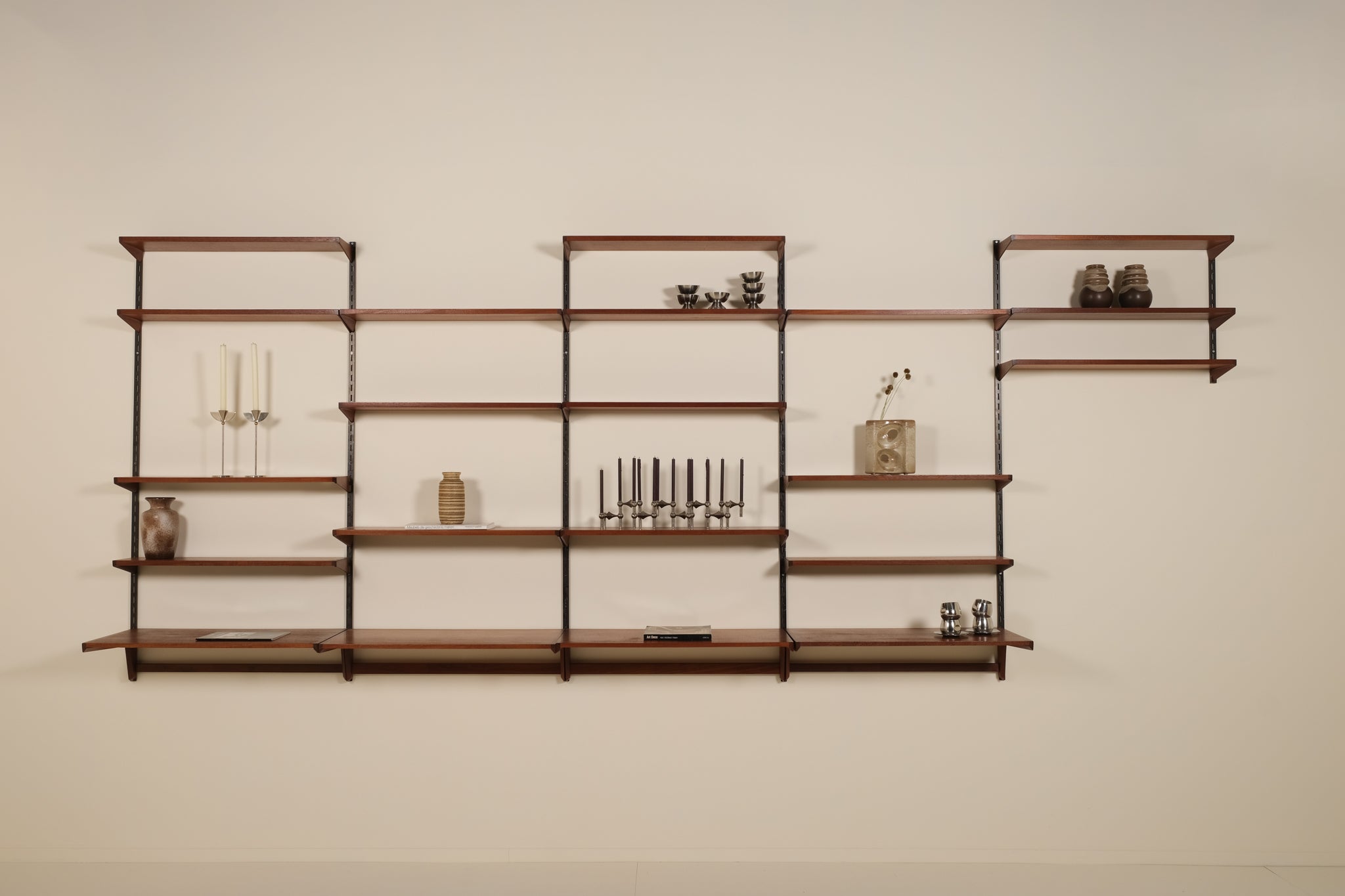 Wooden wall shelf with decorative items against a plain wall