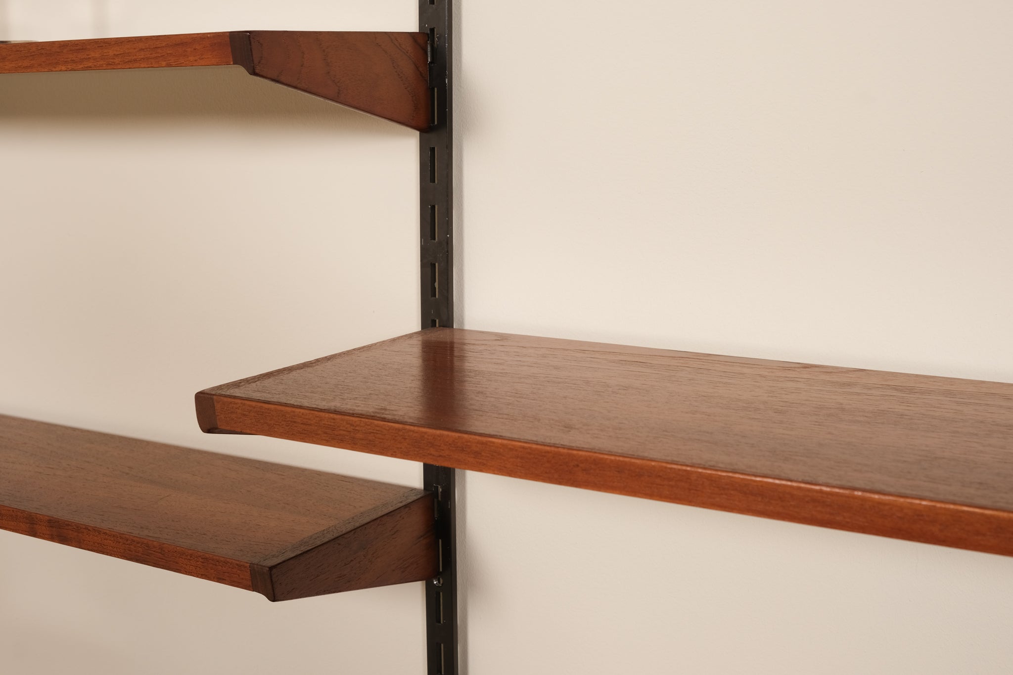 Wooden shelves with metal brackets against a beige wall