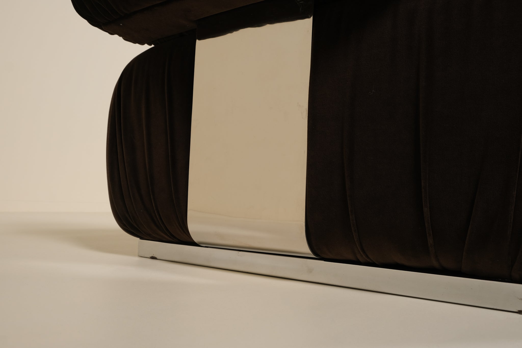 Close-up of a sofa with a metallic base on a beige background