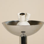 Inside of a chrome floorlamp on a beige background