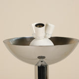 Inside of a chrome floorlamp on a beige background