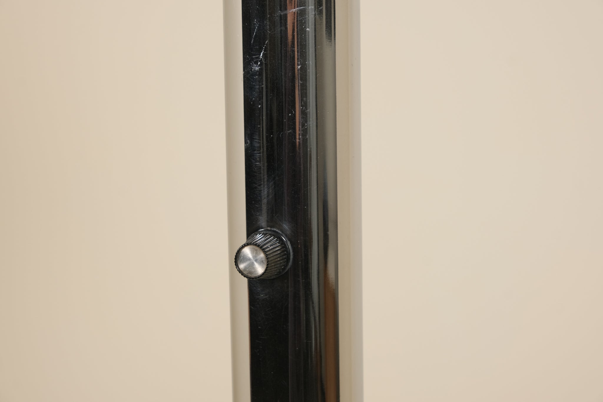 Close-up of a metallic knob on a door with a neutral background