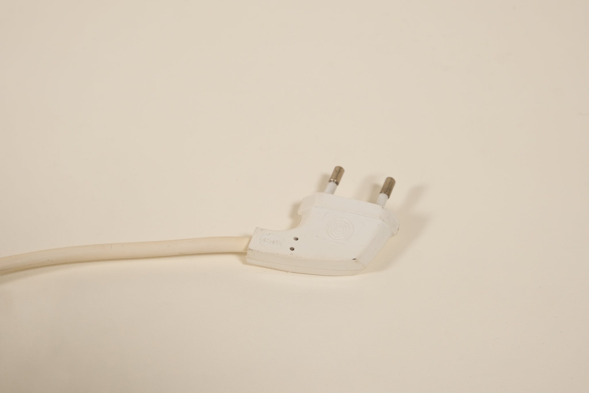 White electrical plug on a beige background