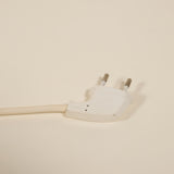 White electrical plug on a beige background